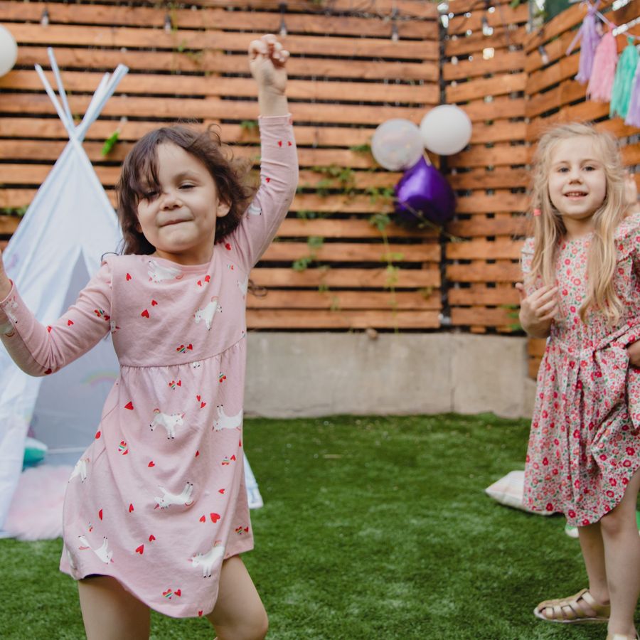Des enfants dansent lors d'une fête en extérieur.